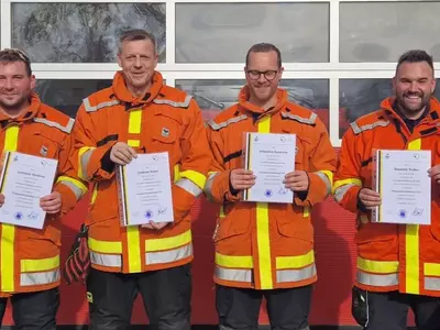 Vier neue Feuerwehrmitglieder präsentieren ihre Urkunde